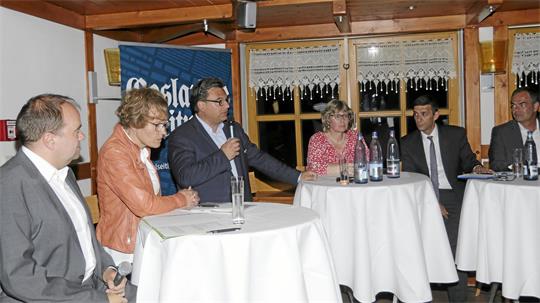 Das Foto zeigt sechs Menschen, von denen einer ein Mikrofon in der Hand hält.