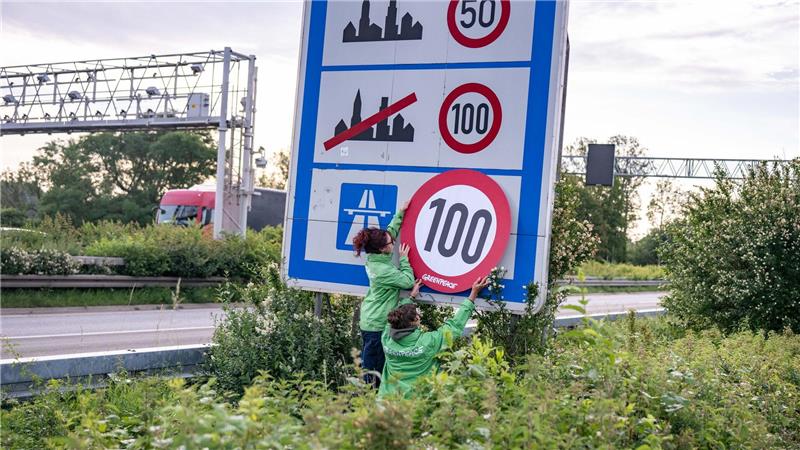 Auf Autobahnen gilt ... ein Tempo-100-Tempolimit? So zumindest wollen es Greenpeace-Aktivistinnen, hier bei der Aktion am Montagmorgen in Aachen. 
