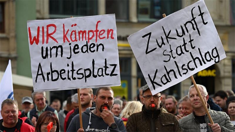 Auf Plakaten machen Teilnehmer der Kundgebung in Zwickau ihrem Unmut über weiteren Jobabbau in der Automobilbranche Luft. 