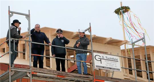 Auf dem Baugerüst im Zeichen des Richtkranzes (v.li.): Zimmermann Frank Besser, Bürgermeister Ingo Henze, Ortsbrandmeister Stefan Rühmann und Architekt Christian Spahn.