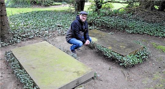 Auf dem Friedhof an der Hildesheimer Straße sollte einst eine Ehrengrabstätte für Mitglieder des Reichsbauernrates entstehen: Spurensuche-Vorsitzender Oliver Turk kniet zwischen den Gräbern von Richard Arauner und Hilmar von der Decken. Foto: Heine