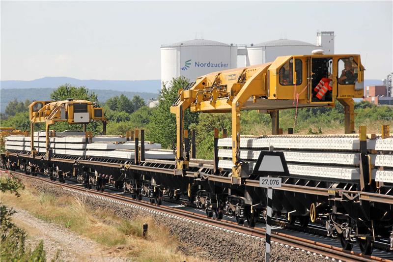 Auf dem Schnellumbauzug fahren Kräne hin und her, um die neuen Schwellen zum Verlegen nach vorne zu transportieren.