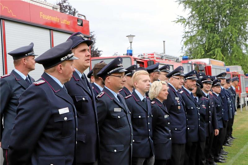 Auf dem Sportplatz in Neuwallmoden treten die Aktiven der Samtgemeinde-Feuerwehren zur Zeremonie an, um die Bandschnalle in Empfang zu nehmen.  Fotos: Gereke