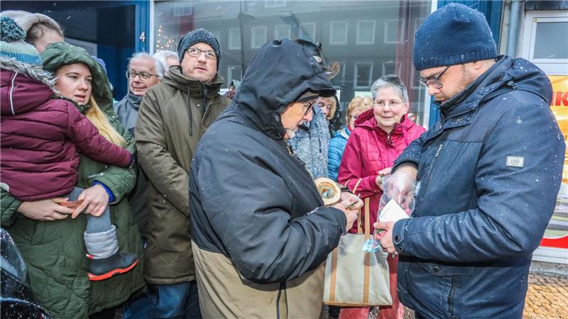 Mehrere Menschen stehen in einer Traube und warten darauf, Glücksschweinchen kaufen zu können.