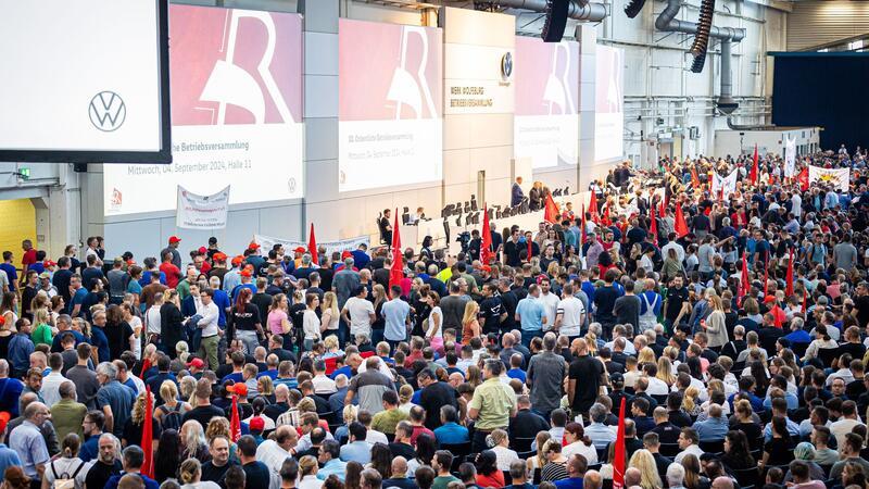Auf der Betriebsversammlung in Wolfsburg begrüßen Mitarbeiter den Vorstand mit scharfem Protest gegen die jüngsten Sparpläne.