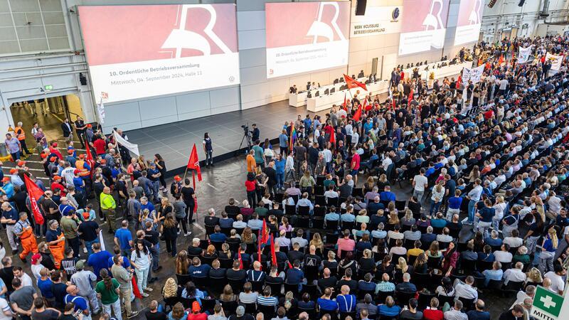 Auf der Betriebsversammlung in Wolfsburg begrüßen Mitarbeiter den Vorstand mit scharfem Protest gegen die jüngsten Sparpläne.