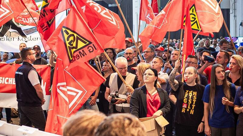 Auf der Betriebsversammlung in Wolfsburg begrüßen Mitarbeiter den Vorstand mit scharfem Protest gegen die jüngsten Sparpläne.