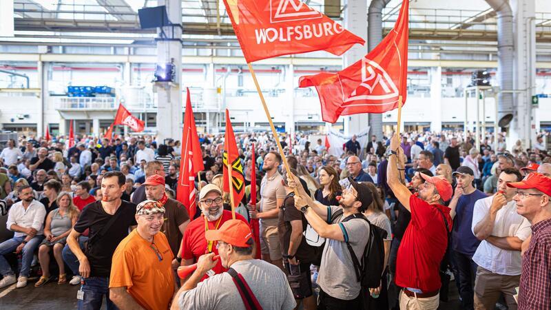 Auf der Betriebsversammlung in Wolfsburg begrüßen Mitarbeiter den Vorstand mit scharfem Protest gegen die jüngsten Sparpläne.