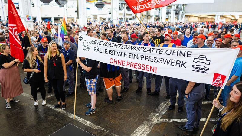 Auf der Betriebsversammlung in Wolfsburg begrüßen Mitarbeiter den Vorstand mit scharfem Protest gegen die jüngsten Sparpläne.