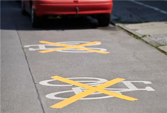 Auf der Ollenhauer Straße sind die Zeichen für den Radweg mit gelben Kreuzen zugeklebt und Autos parken darauf. Der Radweg existiert nicht mehr.