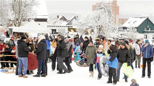 Etliche Menschen versammeln sich auf der verschneiten Skiwiese Rose.