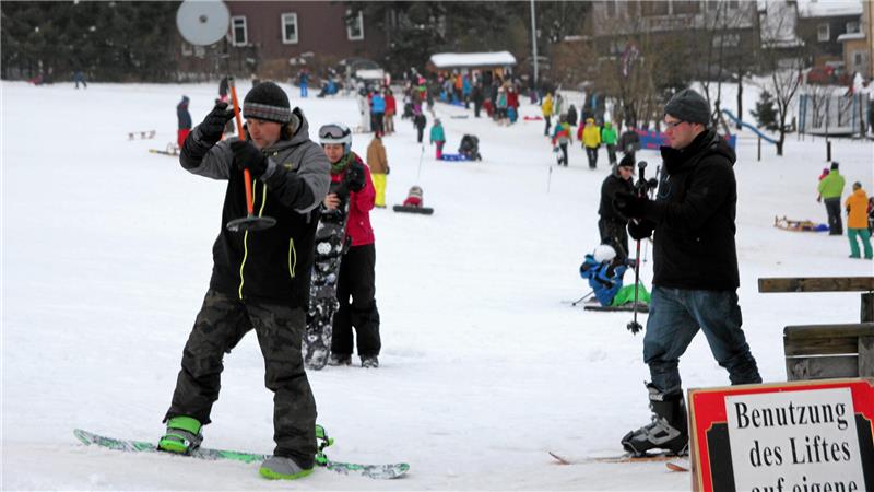 Das Skifahren im Harz wird teurer Das Bild zeigt einen Snowboardfahrer, der sich in den Skilift einklinkt.