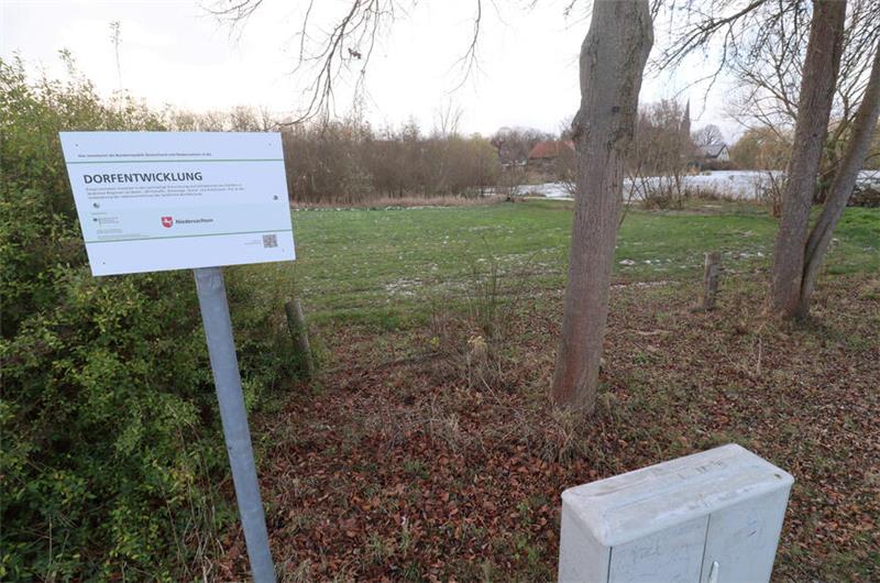 Rasenfläche am Mühlenteich in Lutter, Schild weist auf Förderung durch das Programm "Dorfentwicklung" hin.