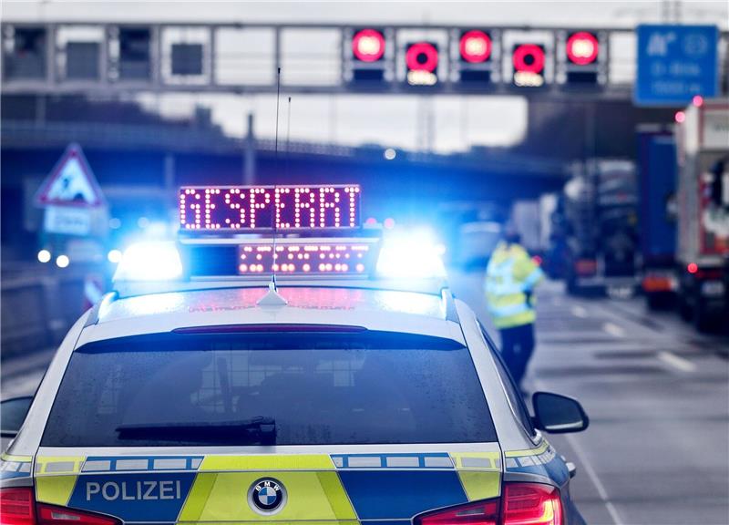 Auf einem Polizeifahrzeug leuchtet die Aufschrift «Gesperrt».