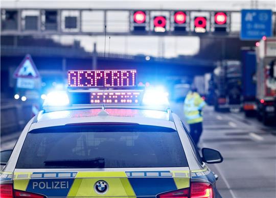 Auf einem Polizeifahrzeug leuchtet die Aufschrift «Gesperrt».