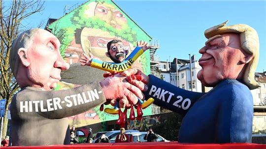 Auf einem der Düsseldorfer Rosenmontagswagen schließen Donald Trump und Wladimir Putin einen „Hitler-Stalin-Pakt 2.0“ auf Kosten der Ukraine ab. 