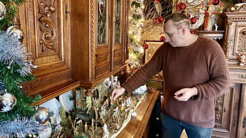 Auf einer Anrichte baut Sven Bartsch die Papp-Krippe auf, die aus dem Jahr 1900 stammt.