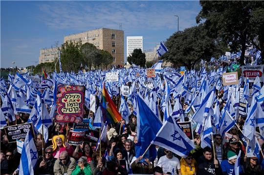 Auf einer Demonstration in Jeruslaem schwenken Protestierende isreaelische Nationalflaggen.