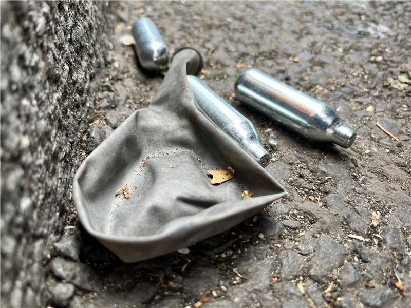 Ärztekammer: Verbot von Lachgas-Verkauf an Minderjährige Auf einer Straße liegen mehrere Gaspatronen und ein Luftballon.