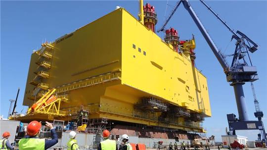 Auf einer Werft in Rostock schwimmt eine Offshore-Konverterplattform im Dock.