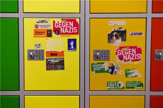 Aufkleber unter anderen mit politischen Botschaften gegen Rechtsextremismus beschmücken Schließfächer an einer Oberschule.