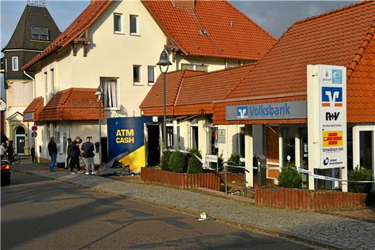 Aufräumarbeiten: Am Vormittag nach der Sprengung eines Geldautomaten der Volksbank in Bockenem. Ein Mann fegt Überreste weg, die nach der Explosion vor dem Bankgebäude liegen. Die Volksbank war im November 2022 bereits Ziel von Kriminellen. Damals stand der Automat im Selbstbedienungsbereich des Instituts.  Foto: Privat