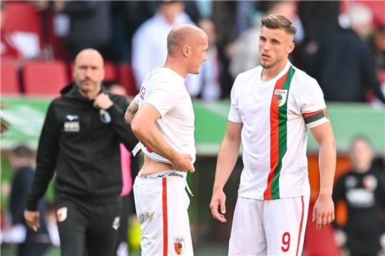 Augsburgs Sven Michel (l) und Augsburgs Ermedin Demirovic (r) reagieren nach dem Spiel unzufrieden.