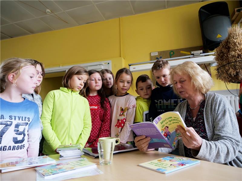 Aus „Warum seid ihr so gemein zu dem?“ liest Annette Weber vor Harlingeröder Schülerinnen und Schülern. Sie ist begeistert von deren Interesse, das sich bei den Spielen zeigt, die sie zwischen die Lesepassagen einbaut. Foto: Potthast