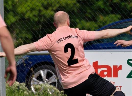Fußballspieler in Aktion auf dem Spielfeld in rosa Trikot mit der Nummer 2 