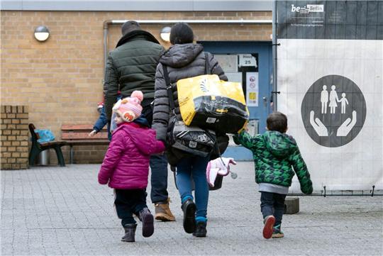 Aus ihrer Heimat geflohene Menschen betreten das Gelände einer Erstaufnahmeeinrichtung in Berlin.