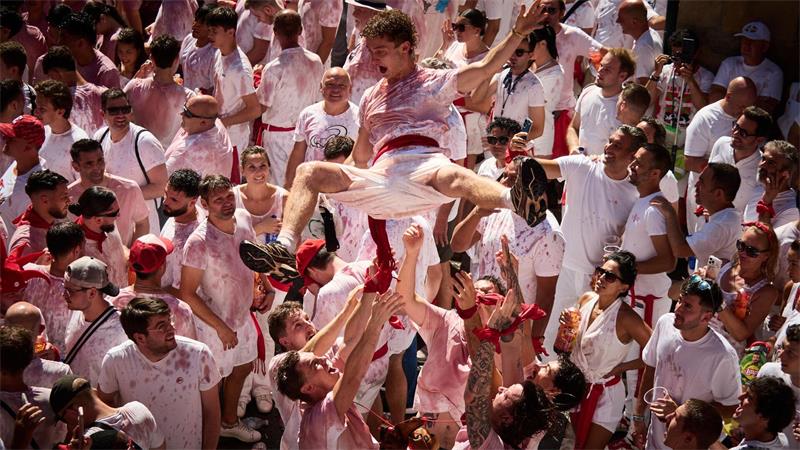 Ausgelassen feiern die Menschen  kurz vor dem Chupinazo beim San-Fermín-Fest 2026 auf der Plaza del Ayuntamiento. Der Chupinazo  ist der offizielle Beginn der San-Fermín-Feierlichkeiten, 