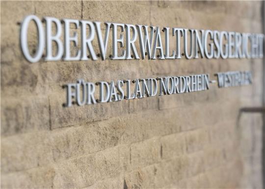 Ausgewichen ist das OVG wegen der großen Zahl an Prozessbeteiligten und rund 100 angemeldeten Journalisten auf die Eingangshalle des Gerichts. Das Gericht selber führt alle Akten mit 15.000 Seiten digital.