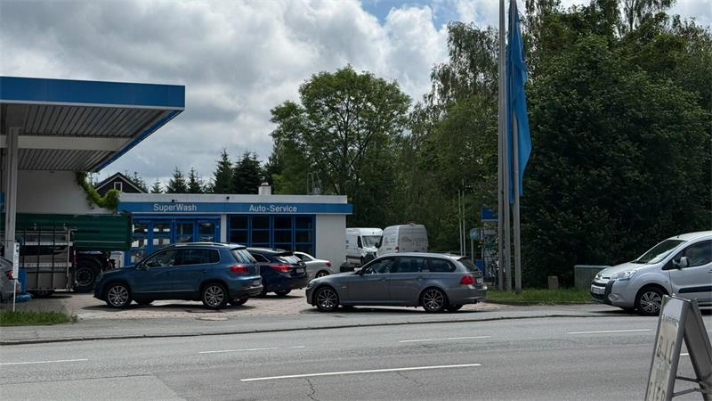 Mehrere Autos stehen an einer Tankstelle.