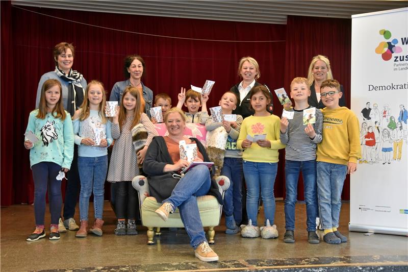 Mit Kinderbüchern gegen Ausgrenzung Autorin Astrid Frank (vorne) liest aus ihrem Buch vor und unterschreibt fleißig Autogrammkarten für die Schüler. Foto: Skuza