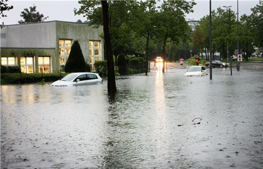 Autos auf einer überfluteten Straße in Münster. Der Grund: Heftige Regenfälle.