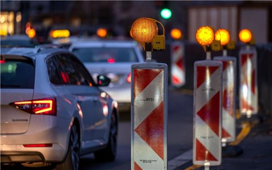 Autos fahren an einer Baustelle vorbei.