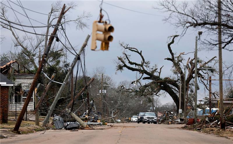 Wetterextreme in den USA bringen Tod und Zerstörung Autos fahren vorsichtig an umgestürzten Bäumen und Stromleitungen in Selma vorbei.