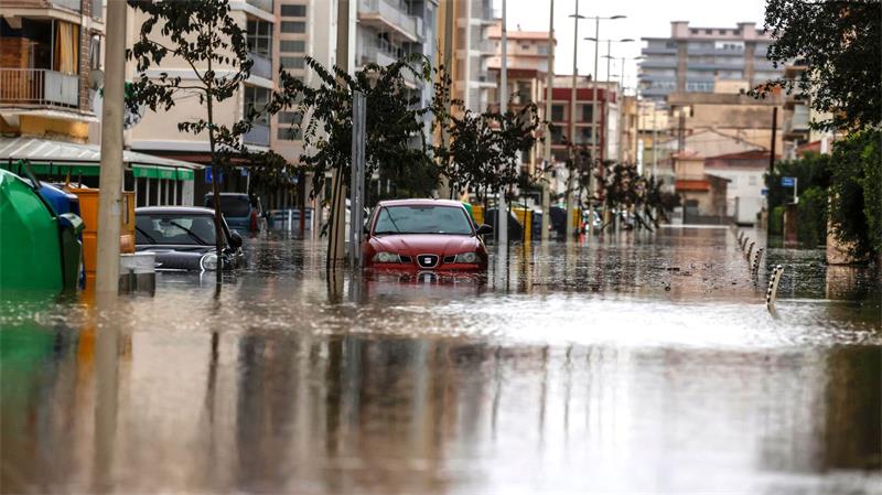 Autos stehen im Hochwasser einer überschwemmten Straße.