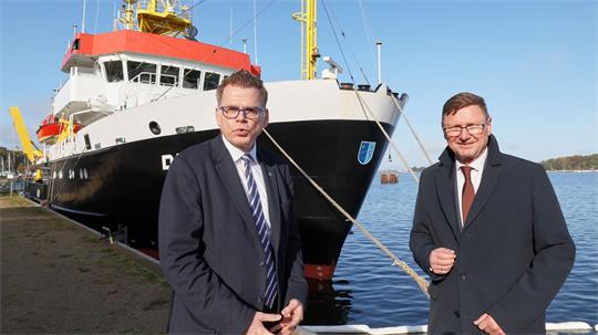 BSH-Präsident Helge Heegewaldt (li) und der gerade aus dem Amt geschiedene IHO-Generalsekretär Mathias Jonas stehen vor dem Forschungsschiff „Deneb“. 