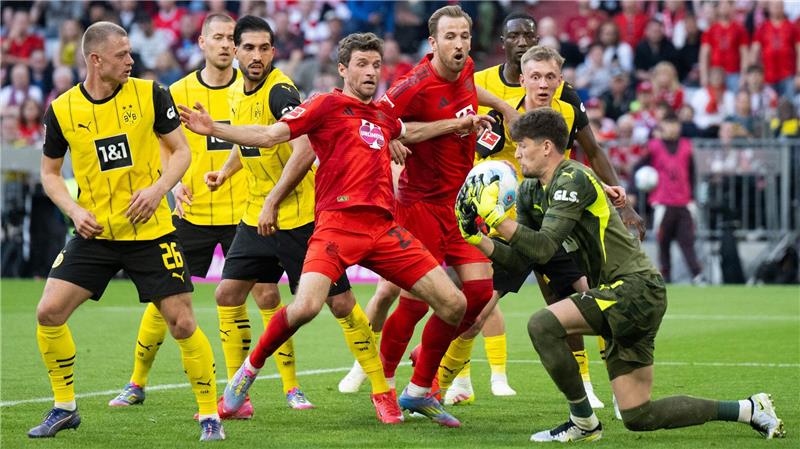 BVB bremst Bayern beim Meisterstück aus: „Tolles Spiel“ BVB-Torwart Gregor Kobel (r) packt vor Thomas Müller (m) zu.