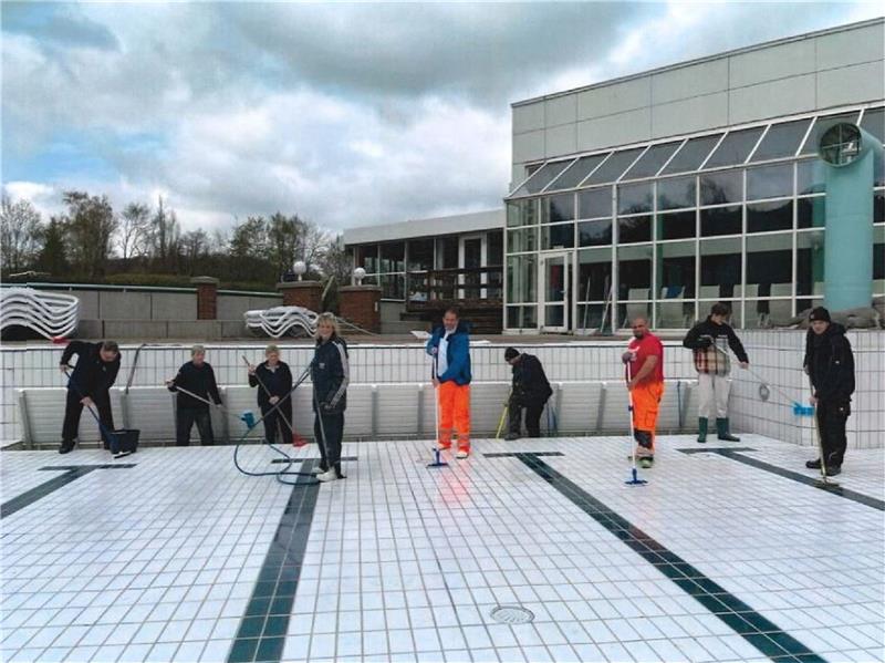 Harzburger Silberbornbad startet am 1. Mai in die Saison Bad-Leiterin Heidi Fiebig (4. v. li.) reinigt gemeinsam mit ihrem Team und Kollegen aus anderen Betriebsbereichen der KTW das Erlebnisbecken des Silberbornbads. Bezeichnet wird die Vorbereitung auf die Saison auch als „Auswintern“. Foto: KTW