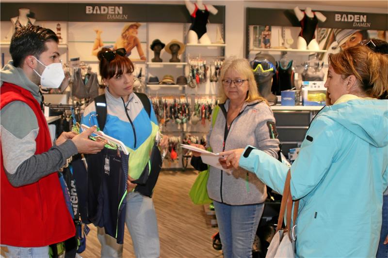 Badehosenkauf: Benjamin Acar berät Andrea Duit-Reith (2. von rechts). Mila Lutsiuk (rechts) übersetzt, was die ukrainische Mutter Svitlana Skakovska sagt. Foto: Knoke