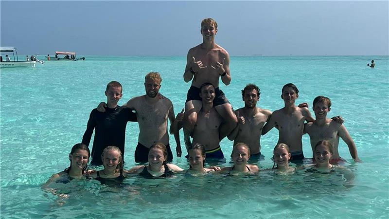 Goslarerin Amalia Saupe trainiert Mädchenteam in Afrika (Teil 2) Gruppe von Menschen steht und sitzt im flachen, klaren Wasser eines Meeres oder Ozeans unter blauem Himmel.