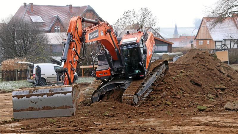 Bagger bei Erdarbeiten, im Hintergrund der Gielder Kirchturm.