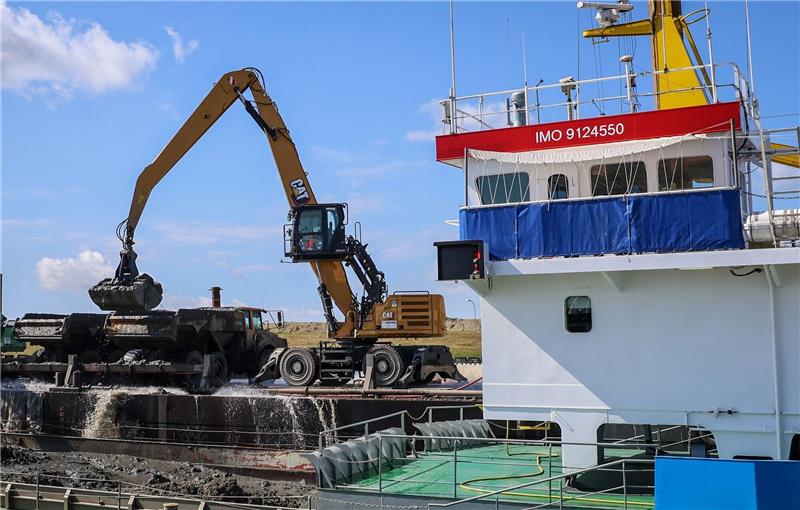 LNG-Terminal: Tschechien sichert sich Kapazitäten in Stade Bagger entladen am Kleilager nahe der Baustelle des LNG Terminals an der Elbe in Stade Klei ein Transportschiff.