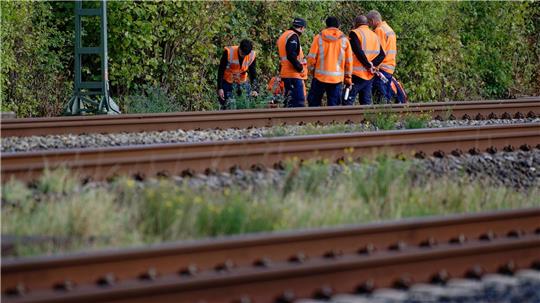 Bahn-Mitarbeiter stehen am Rand der Strecke Köln-Düsseldorf. 