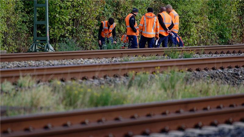 Durchtrennte Bahnkabel in NRW: Polizei geht von Sabotage aus Bahn-Mitarbeiter stehen am Rand der Strecke Köln-Düsseldorf.