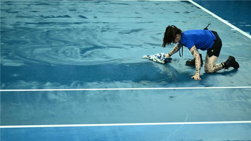 Ballkinder versuchten mit Handtüchern, die Plätze im Melbourne Park wieder zu trocknen.
