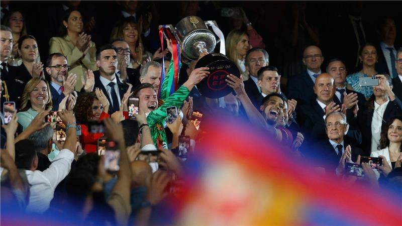 Barcelonas Ronald Araujo (r) und Barcelonas Torhüter Marc-Andre ter Stegen heben den Pokal nach dem Sieg im Endspiel der spanischen Copa del Rey.