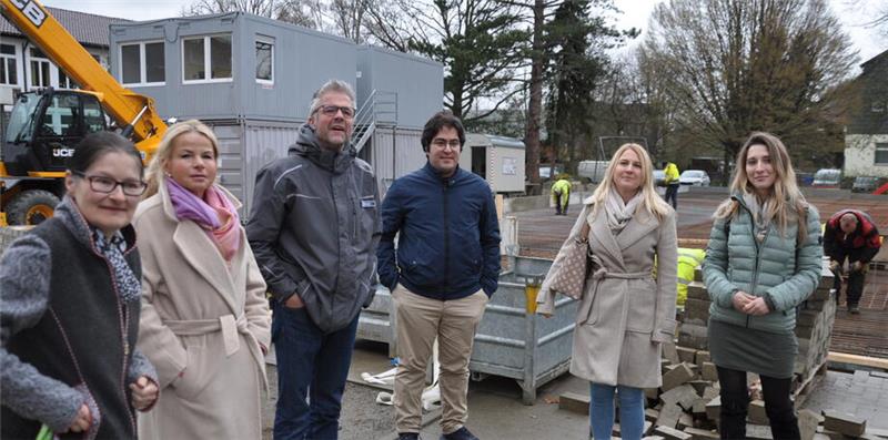 Oker drückt aufs Tempo: Millionenschwere Module rücken an Sechs Personen stehen auf einer Baustelle, im Hintergrund sind Baucontainer, ein Kran und Baumgruppen zu sehen